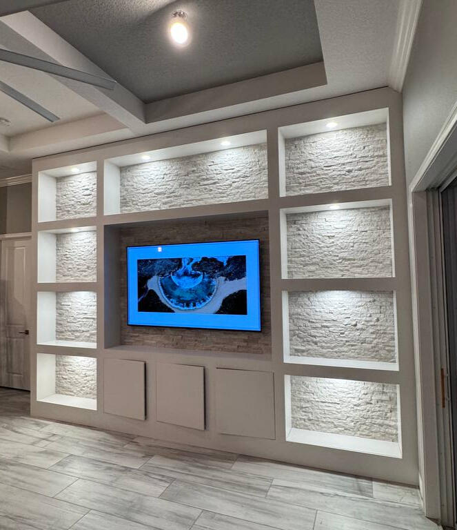 Modern media wall with floating cabinetry, wood slat panels, and linear fireplace in a contemporary San Francisco Bay Area home
